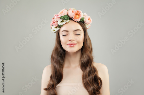 Relaxation and aromatherapy concept. Spa model woman with clear skin and flowers on gray background