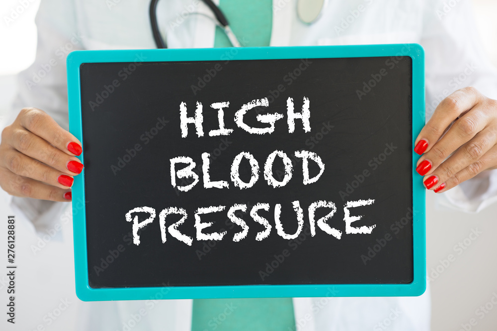High blood pressure alert written with chalk on small blackboard held by doctor