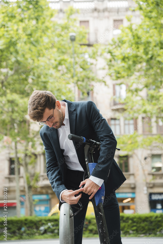 Businessman adjusting the strap of electric scooter