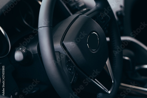 Audio control buttons on the steering wheel of a modern car © Nana_studio