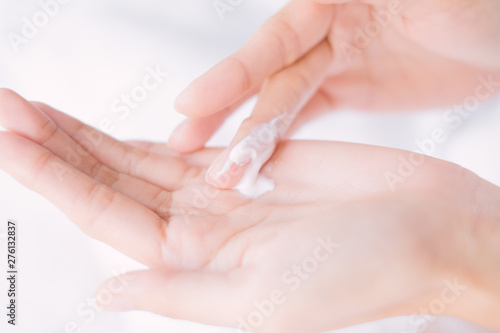 Close up woman applying moisturizing cream/lotion on hands, Top View, beauty concept.