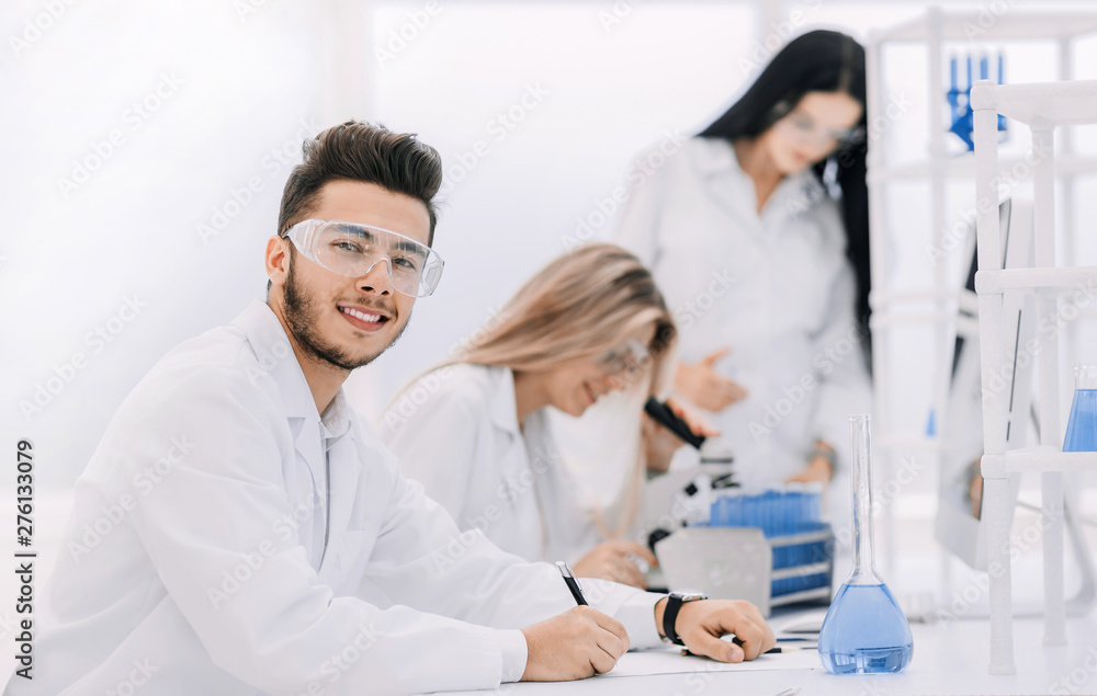 close up.young scientist sitting at his Desk in the laboratory close up.young scientist sitting at his Desk in the laboratory