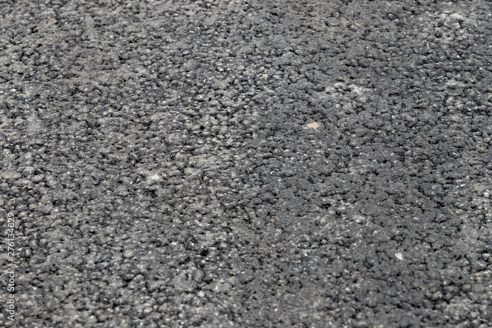 A smooth dark grey asphalt pavement texture with small rocks Stock