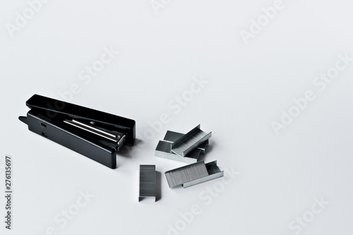 Stapler black with paper clips isolated on white background.