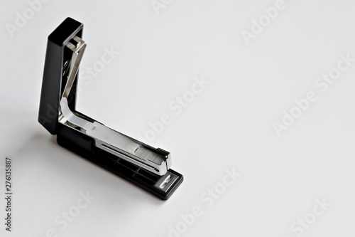 Stapler black with paper clips isolated on white background.