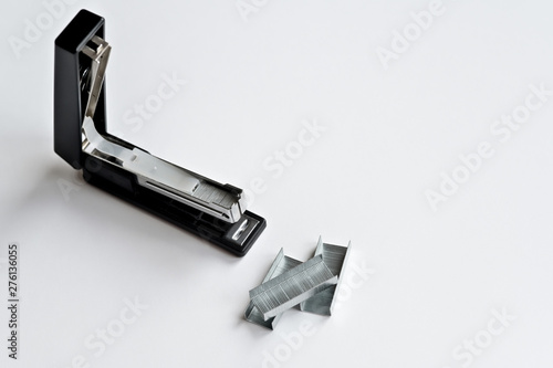 Stapler black with paper clips isolated on white background.