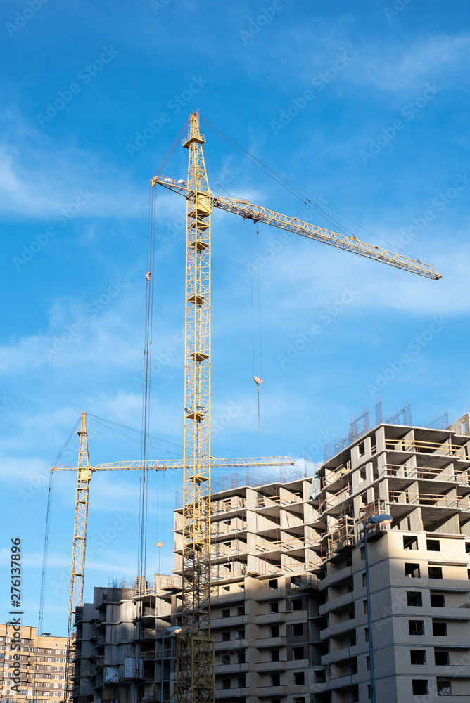 Crane in the process of building a new building against the sky Crane in the process of building a new building against the sky