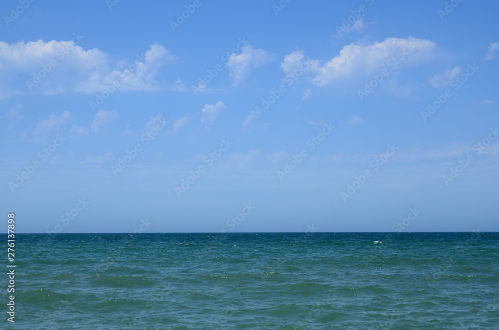 Seashore in summer, with clouds in the sky, with waves