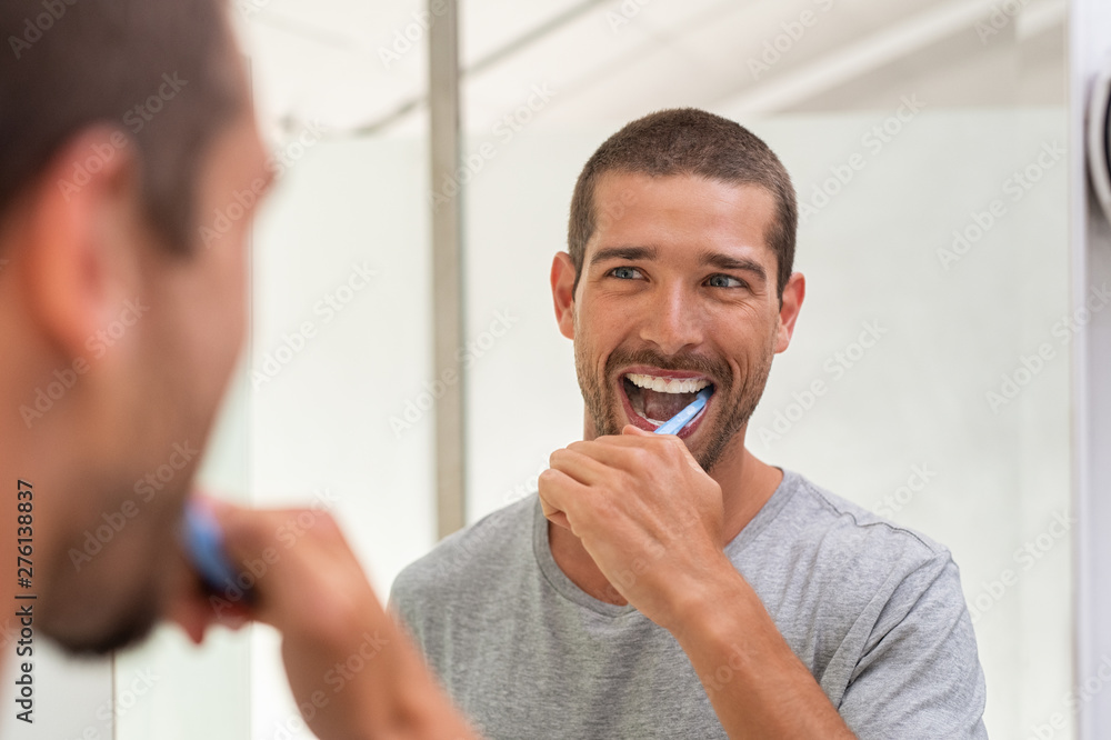Happy man brushing teeth - obrazy, fototapety, plakaty 