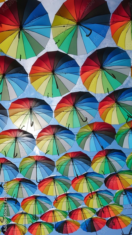 A huge number of umbrellas rainbow-colored fly into the sky