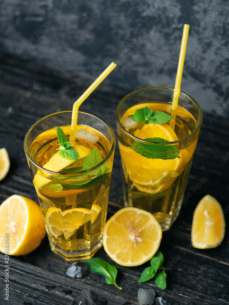 Fototapeta premium Summer lemonade Mojito with lemon and mint in glasses on a dark table