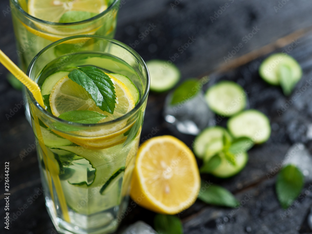 Summer cold lemonade with cucumber lemon mint Basil and ice in glasses Summer cold lemonade with cucumber lemon mint Basil and ice in glasses