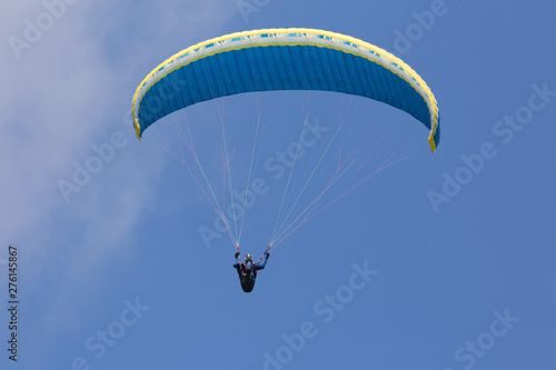 Colorful paraglider wing or canopy against blue sky with clouds