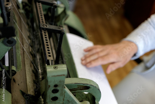 Machine for stitching book pages with threads in typography.