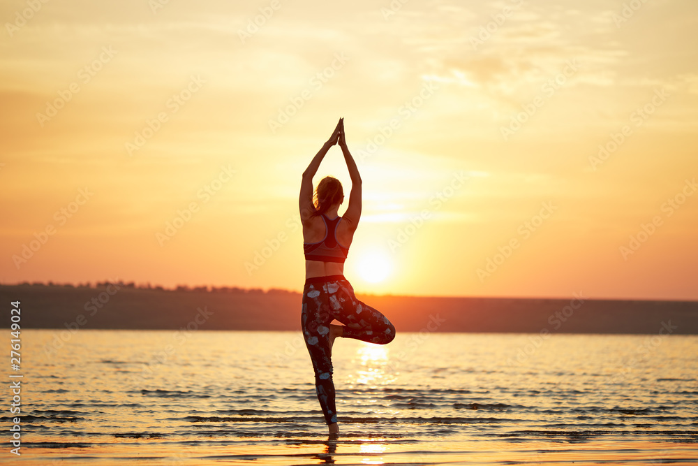 Yoga and fitness. Young woman practicing morning meditation in nature at the beach