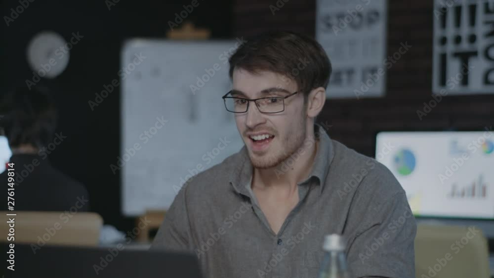 Happy business man checking report in front of laptop in dark office. Happy business man checking report in front of laptop in dark office.