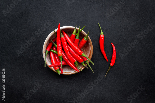 Fresh red chilli pepper as food ingredient on dark table background top view