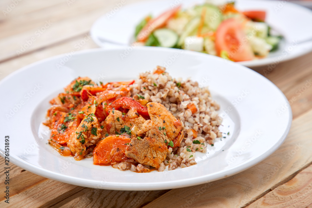 meat with buckwheat and salad on the wooden background meat with buckwheat and salad on the wooden background
