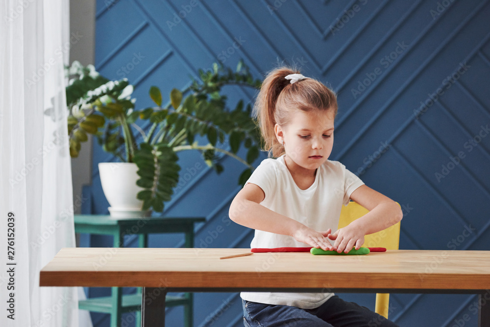 Children playing with colored plasticine on the wooden table at home Children playing with colored plasticine on the wooden table at home
