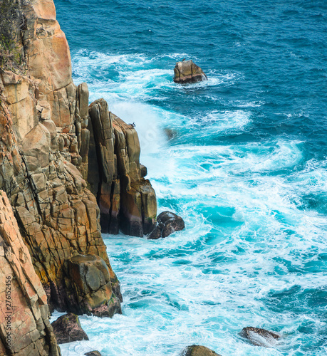 Blue sea with rocky shore in sunny afternoon