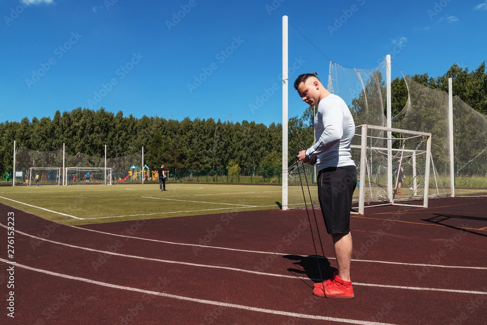 athletic man at the stadium with a rope. Healthy lifestyle. Sport activities on the street