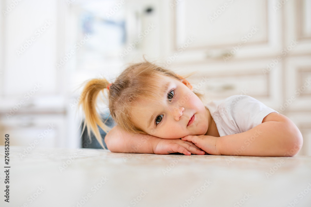 Adorable baby girl in white sunny bedroom. Newborn child relaxing on a blue bed. Nursery for young children. Newborn kid during tummy time with toys at a window Adorable baby girl in white sunny bedroom. Newborn child relaxing on a blue bed. Nursery for young children. Newborn kid during tummy time with toys at a window