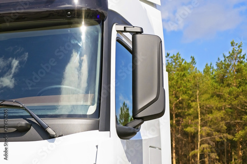 part of the cab of a truck with a forest in the background