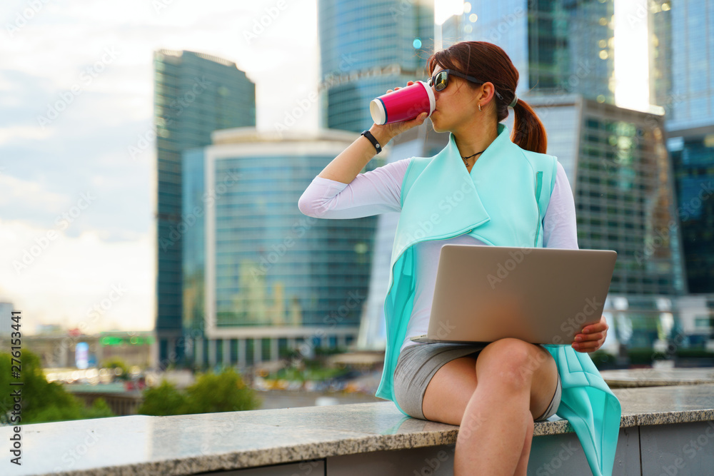 Fototapeta premium Portrait of business woman sitting with laptop and cup of coffee