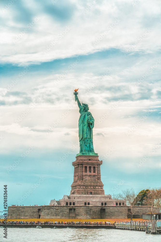 New York City Statue Of Liberty on Liberty Island Against Cloudy Blue Sky Background. Copy Space, Patriotism, Travel Concept. Vertical Banner