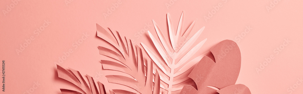 bunch of paper cut palm leaves on pink background, panoramic shot