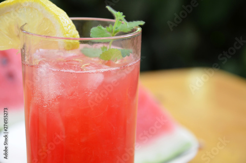 Colorful tropical fresh watermelon smoothie summer drinks in the glasses on wood table background. Refreshing watermelon coсtail with slimon of green foliage. The concept of leisure, travel