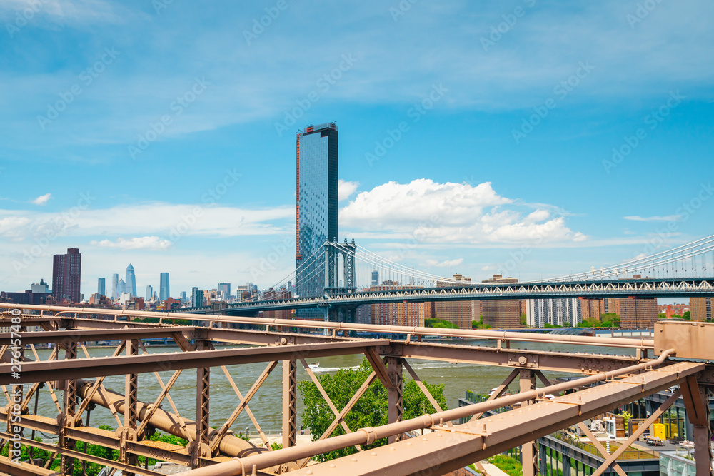 New York City, Brooklyn Bridge and Lower Manhattan Skyscrapers. Cloudy Blue Sky Background
