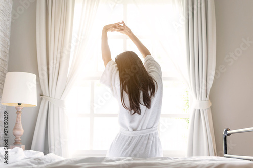 asian woman relaxing in the hotel room, strectching out, copy space