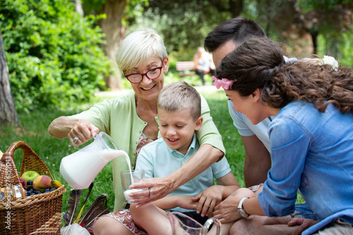 Happy family playing and enjoying picnic with children outside