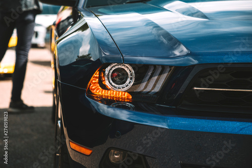 Modern luxury car headlight. Man next to the classic american car. Trendy photo effect. © bulgn