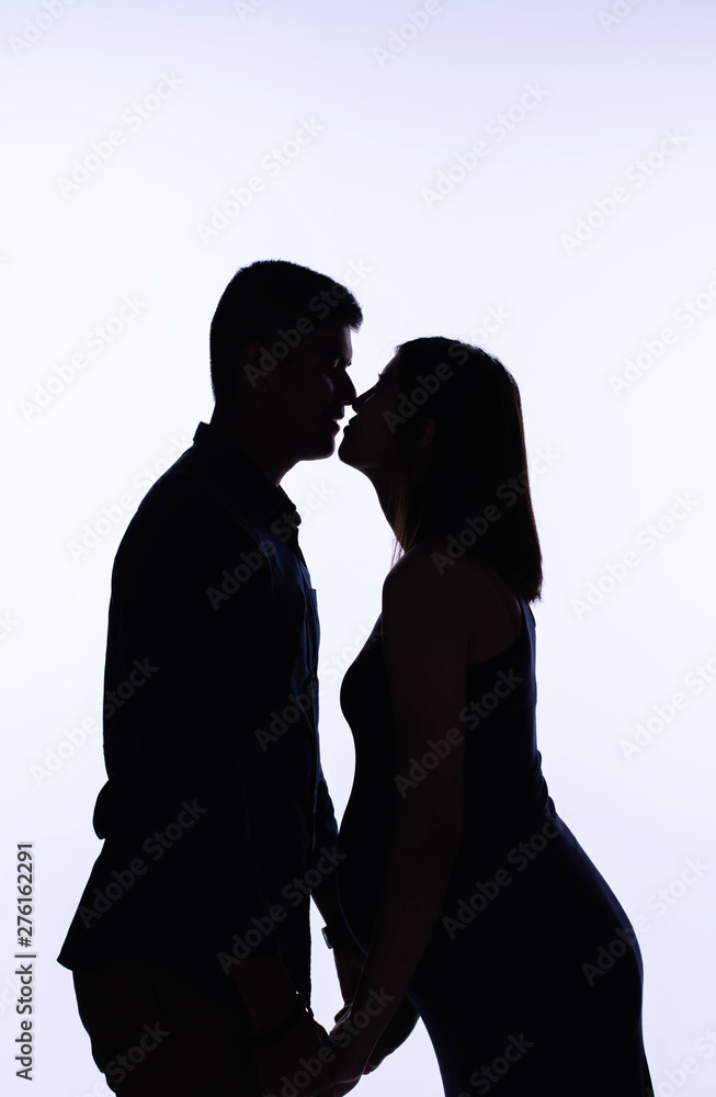 The silhouette of pregnant woman and her husband,holding hand together,with love and care