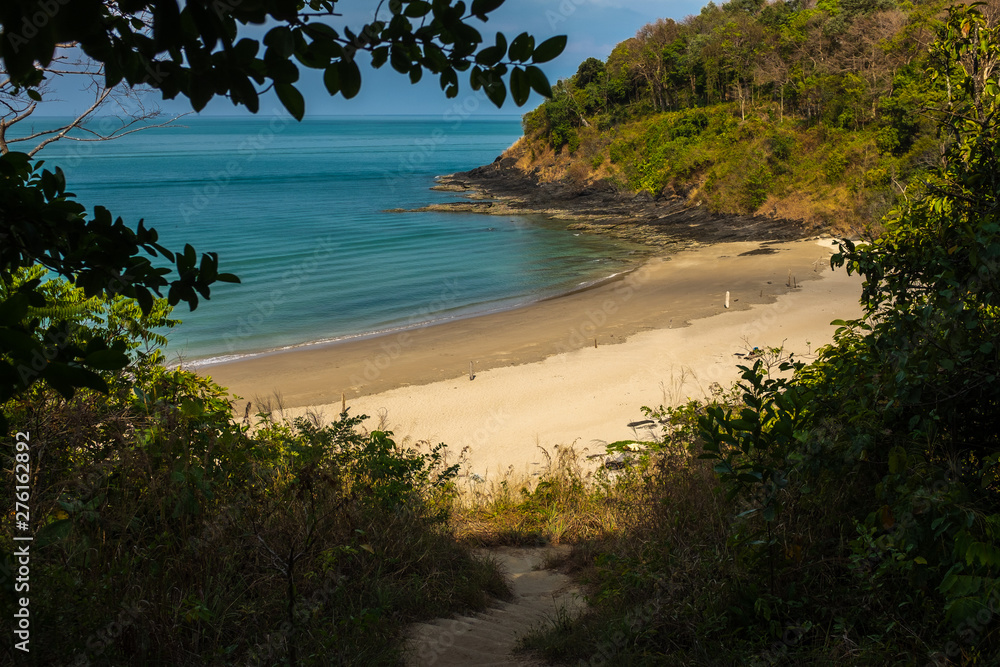 A beautiful small cove beach on the island of Koh Lanta, Thailand with the sparkling waters of the Andanman Sea, framed by greenary. A beautiful small cove beach on the island of Koh Lanta, Thailand with the sparkling waters of the Andanman Sea, framed by greenary.