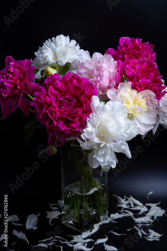 Bouquet of peonies with water drops. Black background. Close-up, selective focus.