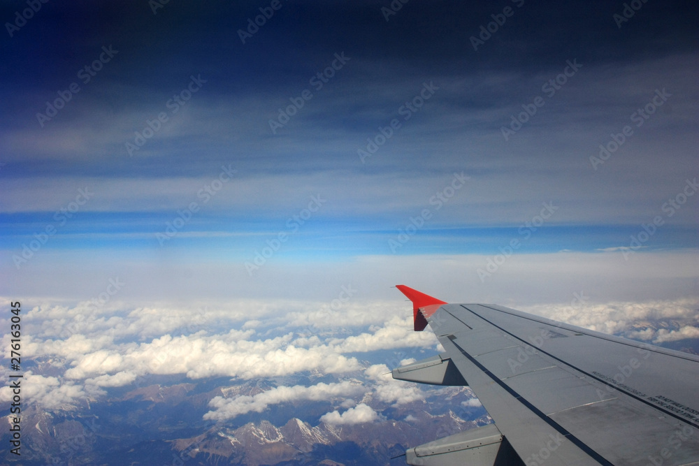 Obraz premium Airplane wing in the blue sky