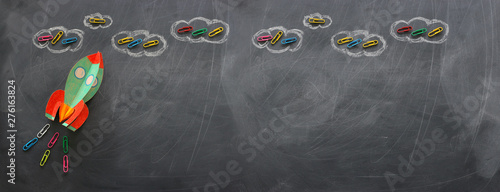 education. Back to school concept. rocket cut from paper and painted over blackboard background. top view, flat lay. banner