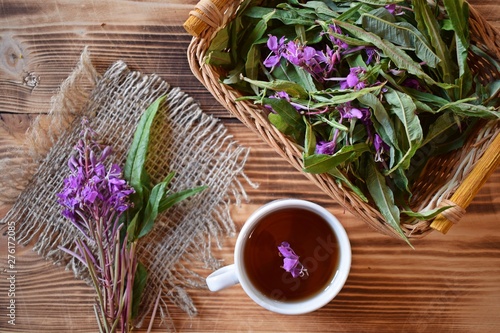 Traditional Russian herbal drink. Ivan-tea in a Cup close-up on a wooden table. It has a positive effect on the human body.