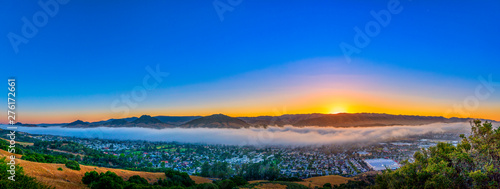 Panorama of View of City below the Clouds and Sunset