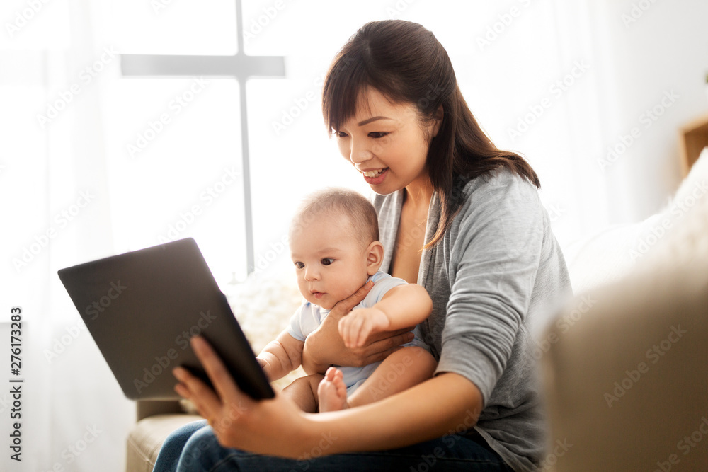 family, technology and motherhood concept - happy smiling young asian mother with little baby son and tablet pc computer at home family, technology and motherhood concept - happy smiling young asian mother with little baby son and tablet pc computer at home