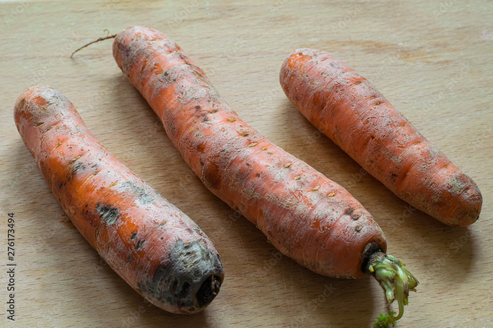 Fresh carrots on a wooden surface. Harvested carrots ready for cooking Fresh carrots on a wooden surface. Harvested carrots ready for cooking