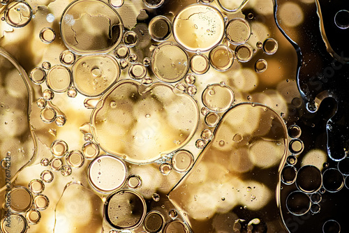 Black and gold abstract pattern made with oil bubbles on water