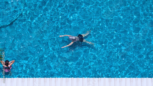 Swimming pool top view angle which blue color clear water and sun light reflect on surface texture and concept images for relaxation or vacation or sport in the tropical summer and for healthy lifesty