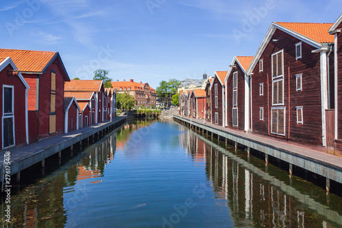 Old red wooden port warehouses next to the water in Hudiskvall historic center, Sweden photo