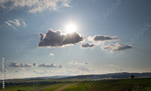 Hot day, the sun shining fiercely from behind the clouds