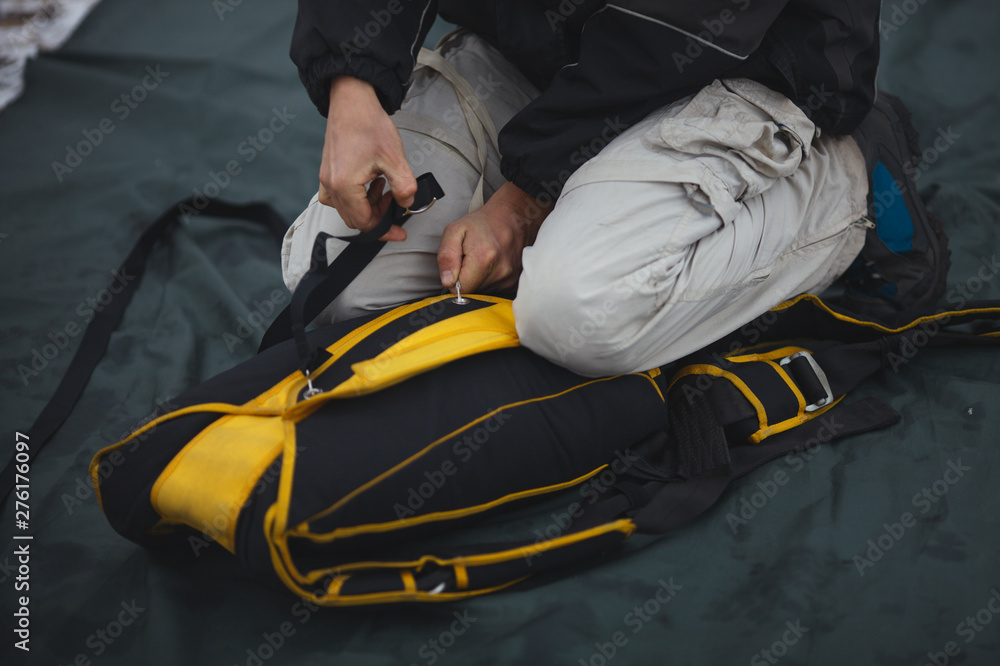 Base jumper packs the parachute before jumping, closeup. Parachute