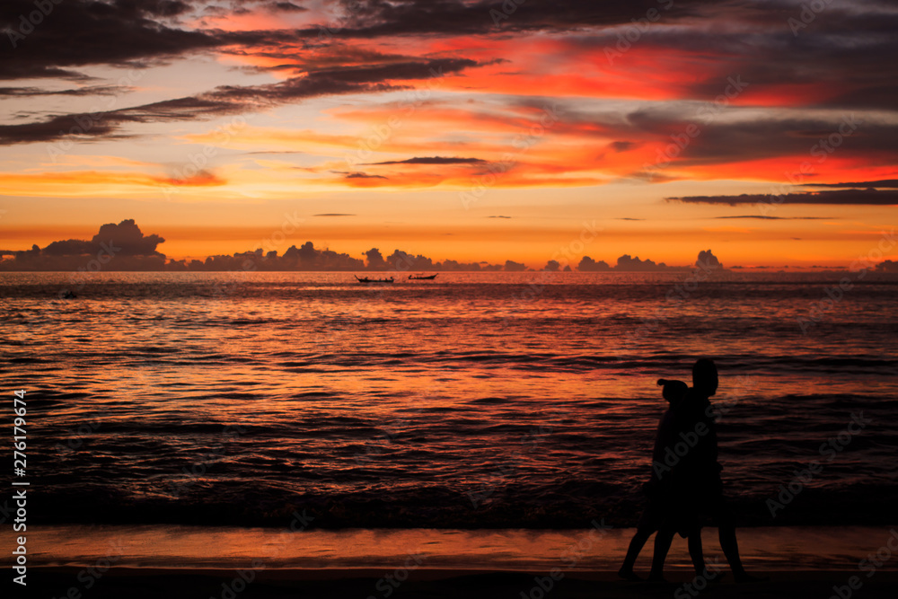 Background sky sunset,Silhouette Jogging on the beach,Bright in Phuket Thailand.